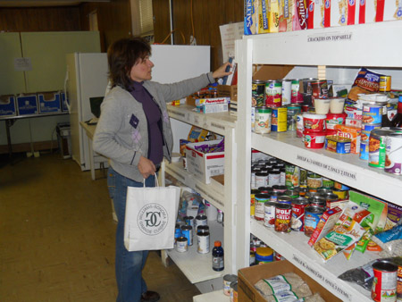 Volunteer shelving food donations